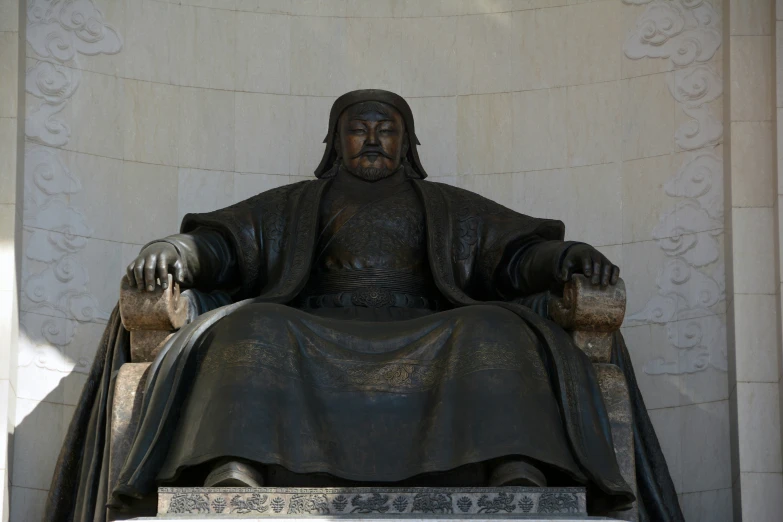 a statue of a man with beard and long black hair is sitting