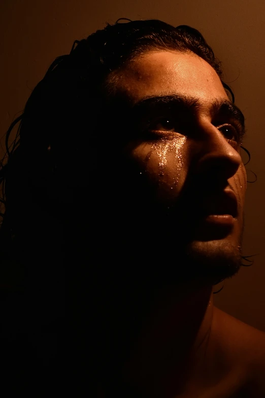 a man with dark face and water on his face