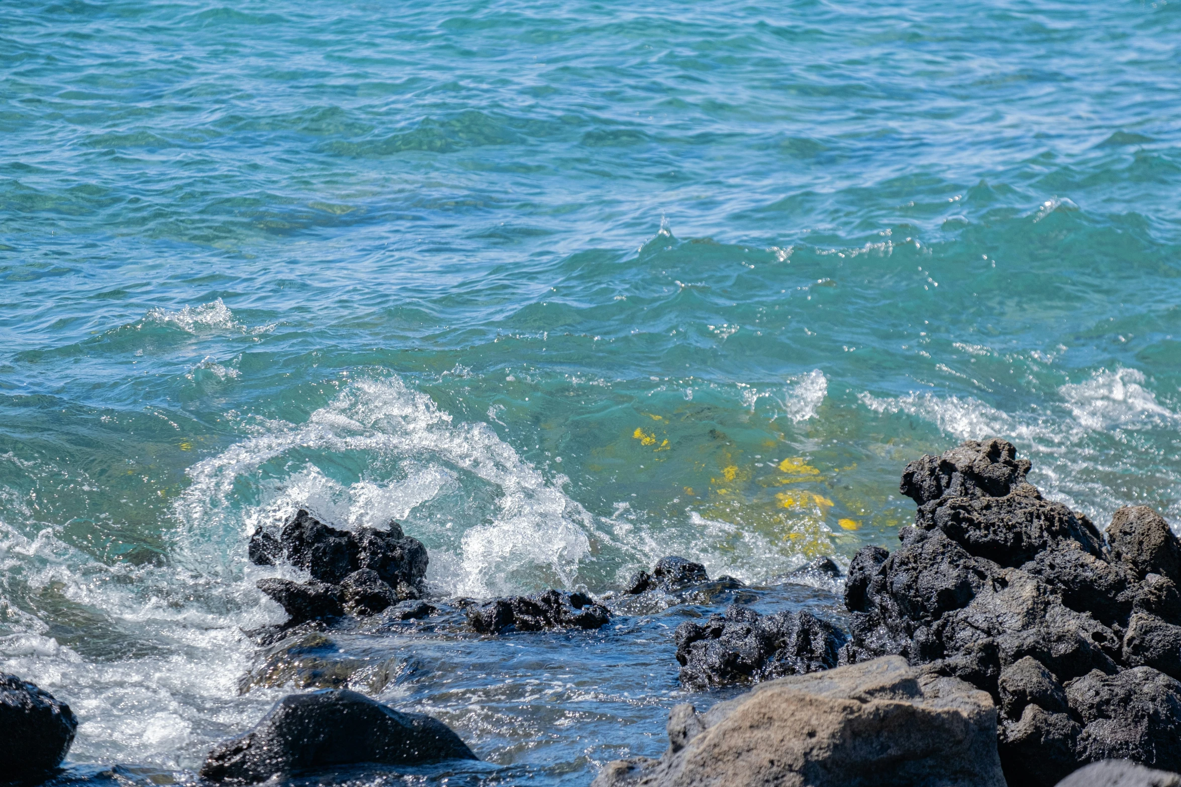 water splashing over rocks on a sunny day