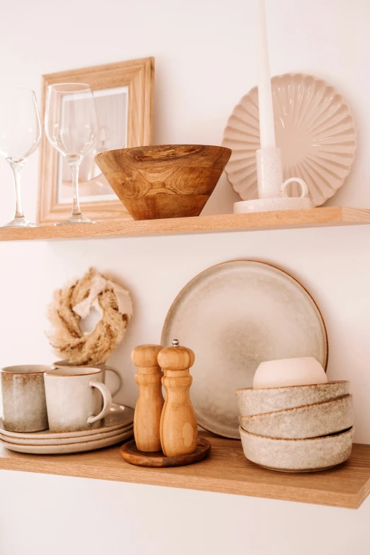 two shelves holding plates, cups, and other dining ware