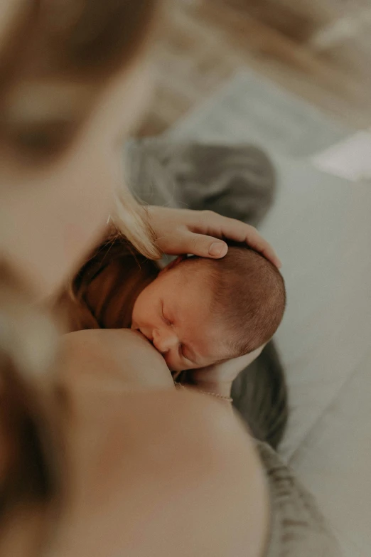 a woman holding a newborn baby while in a bath room