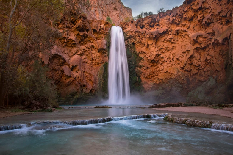 a waterfall with water going down a steep hill side