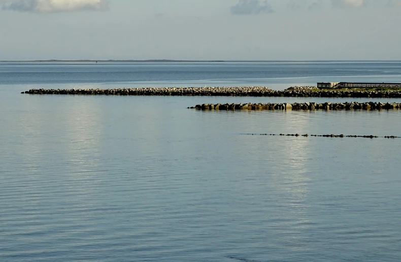 a body of water filled with lots of water next to a lighthouse