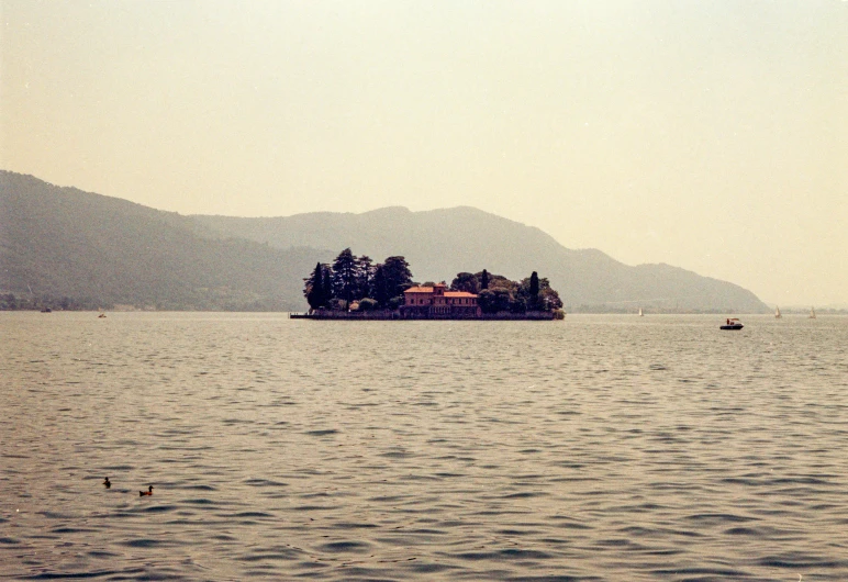 a body of water surrounded by mountains and a small island