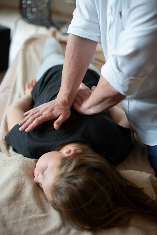 woman doing massage of her child on the back of a table