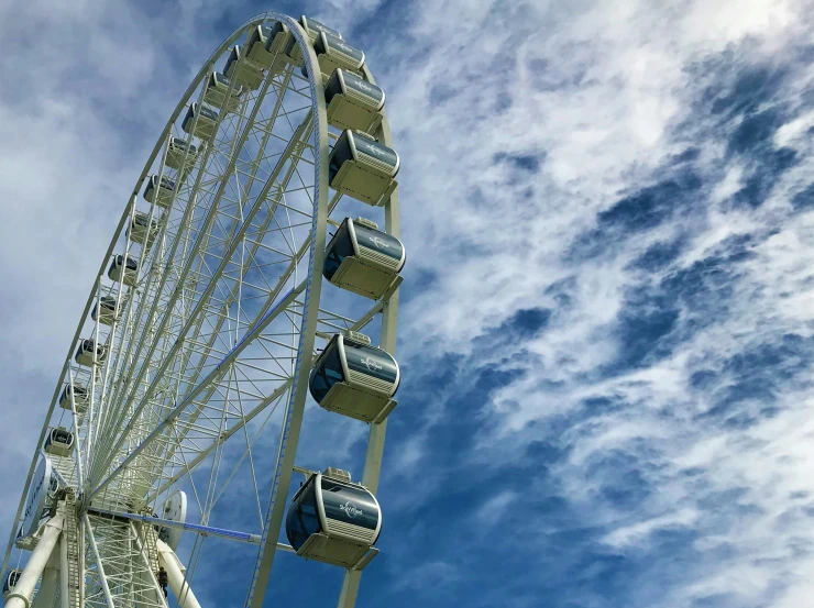 the ferris wheel is very tall and has eight people sitting on it