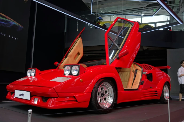 a red sports car parked on display in a building