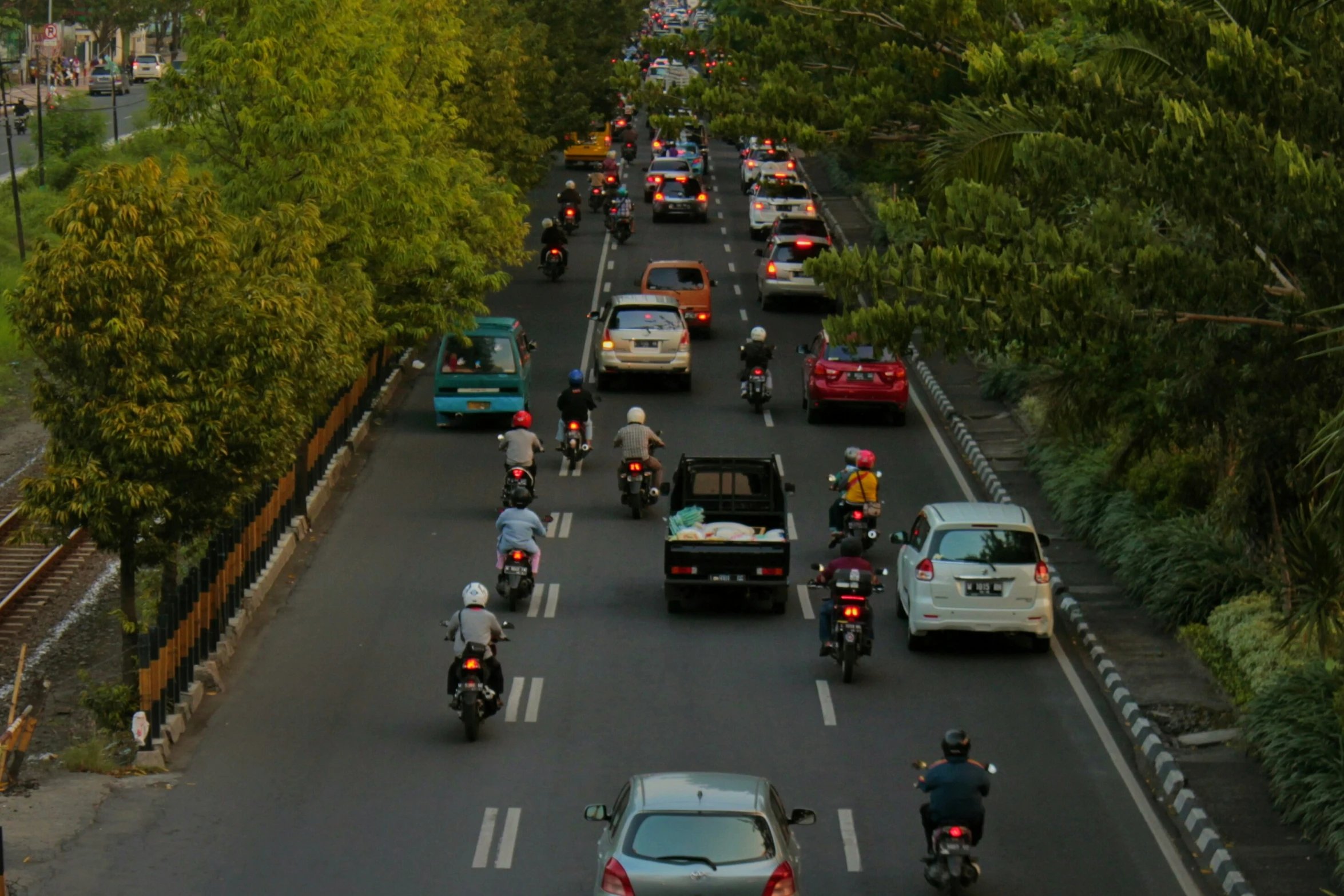 a street filled with traffic with cars and motorcycles