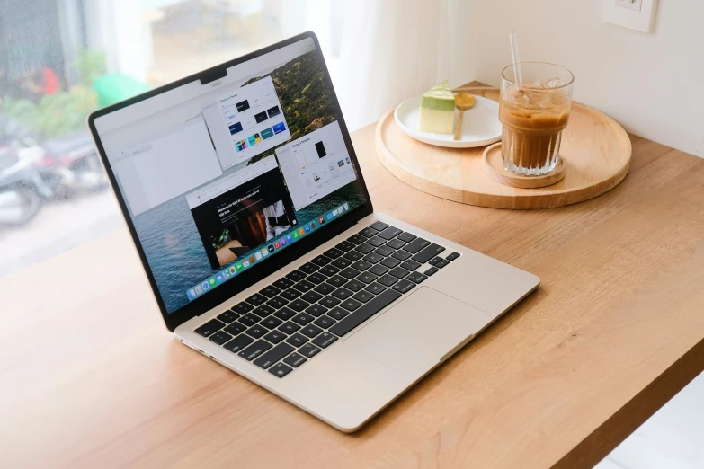 a laptop is sitting on a desk by a cup and plate