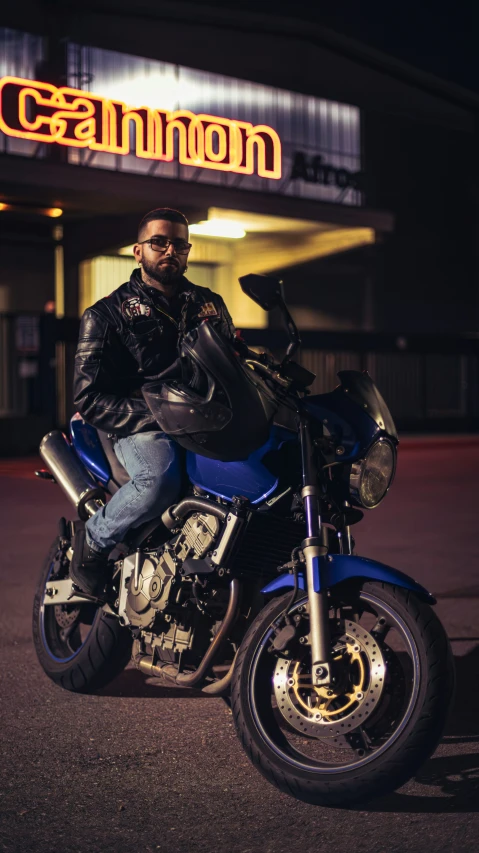 a man sitting on a motorcycle wearing a leather jacket