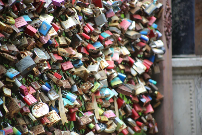 a group of locks attached to a wall that is adorned with words and numbers