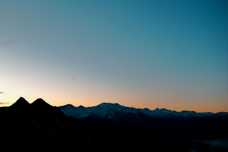 the silhouette of a mountain is shown at sunrise