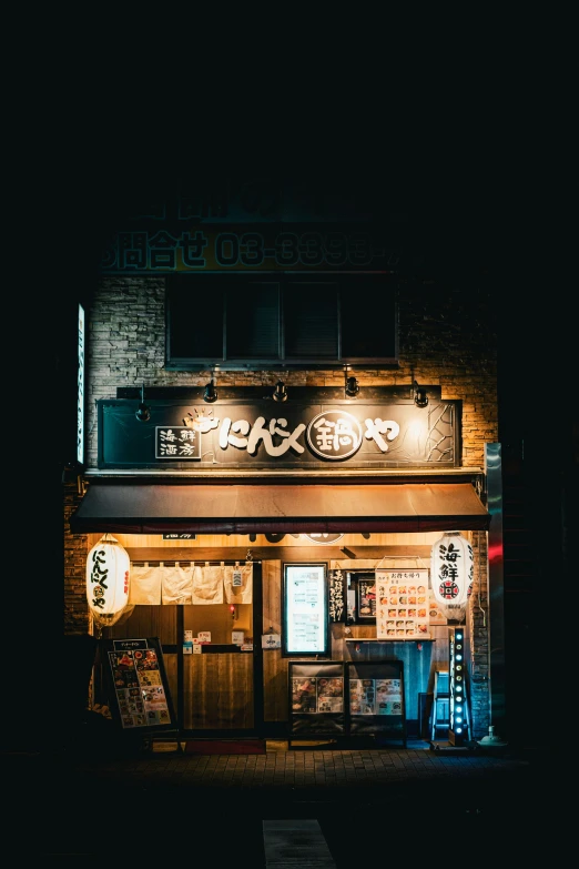 a restaurant with signs outside lit up at night