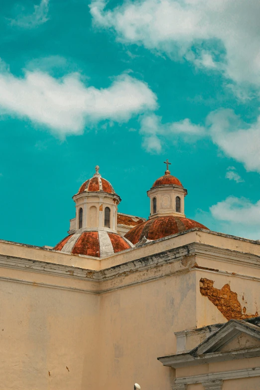 two large brick buildings with a cross on top