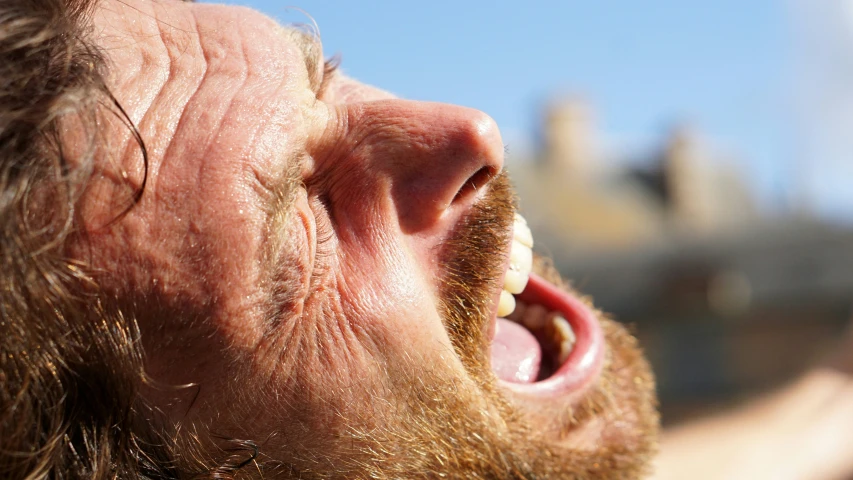 a bearded man in an open mouth looking up