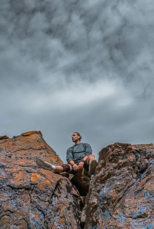 a man sitting on top of a rocky cliff