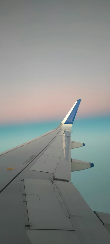 looking out the window at the tail end of an airplane wing