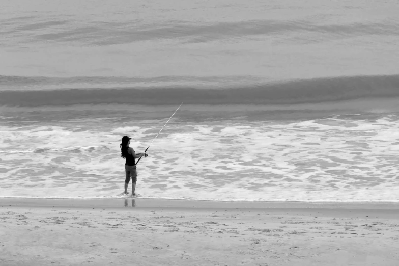 a woman holding a kite on a beach by the ocean