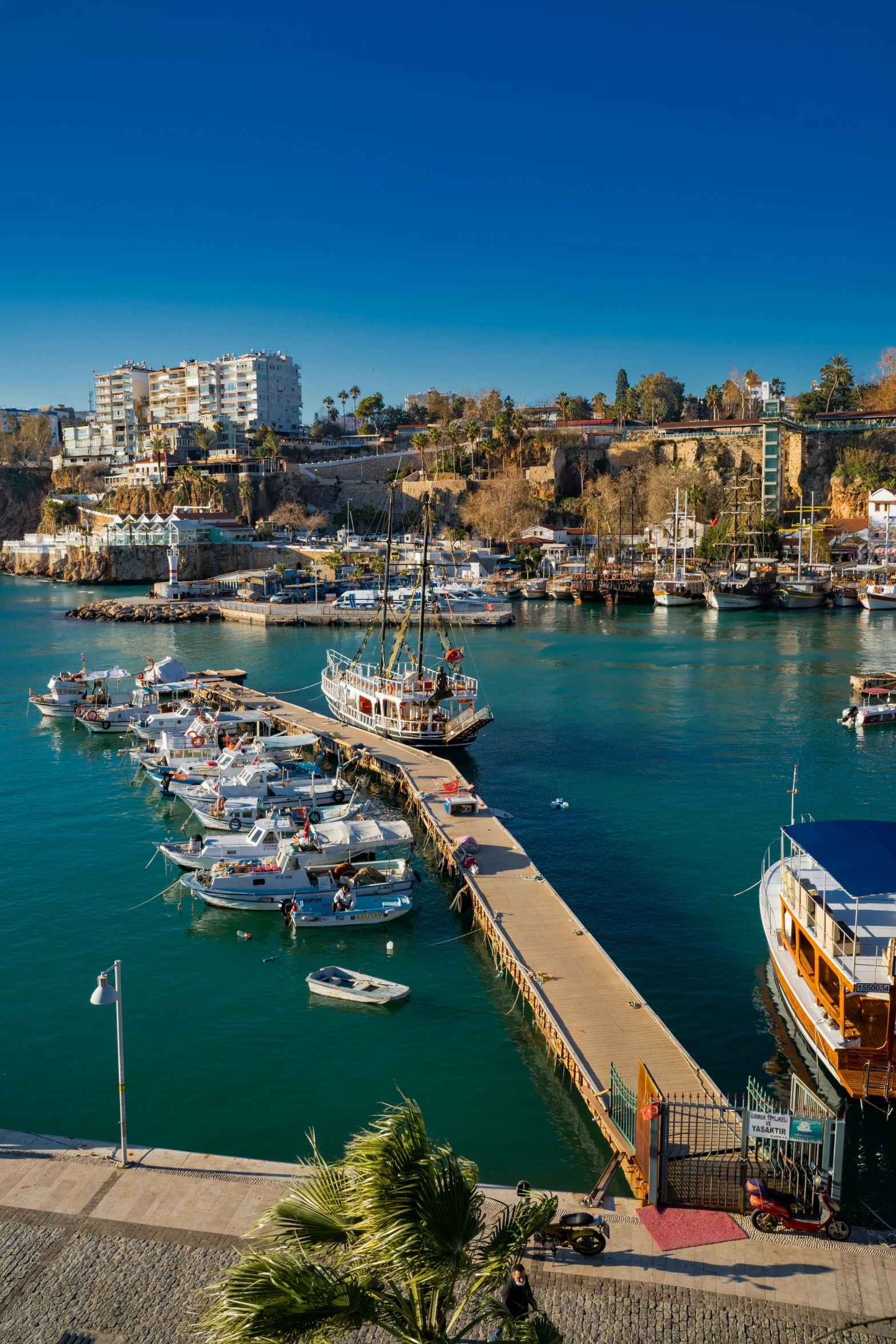 several boats parked along the pier near the city