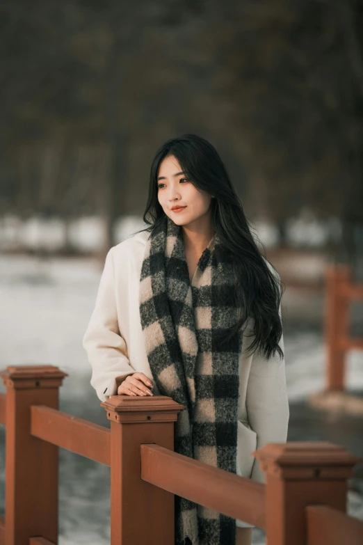 woman standing on bridge wearing a black and white scarf