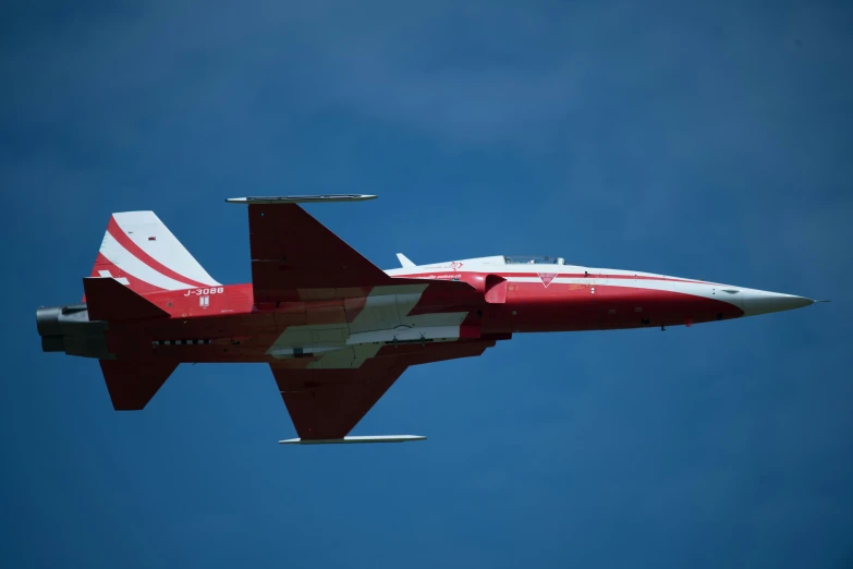 a jet airplane flying through the air on a sunny day