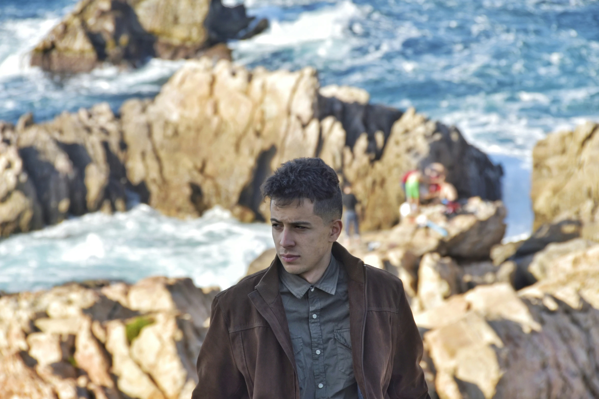 a man walking along the shore next to the ocean