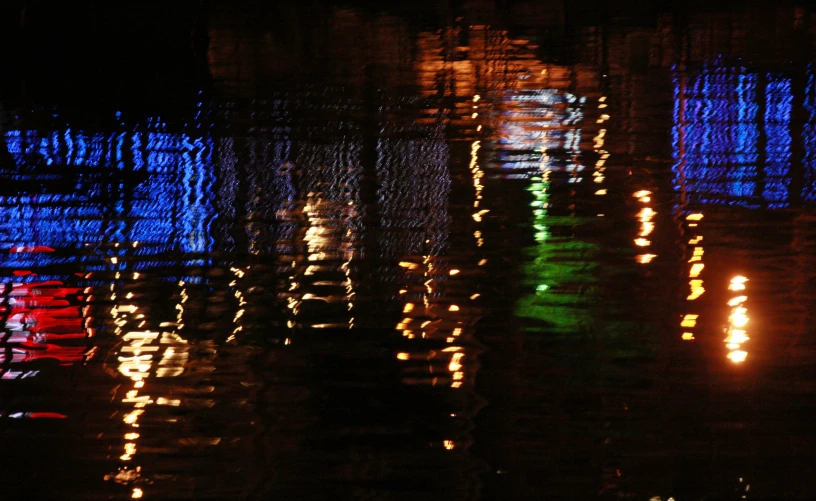 lights reflecting in the water on a city street