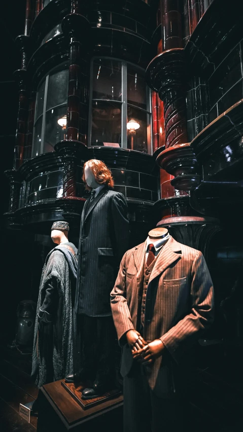 some suits and ties on display in the dark