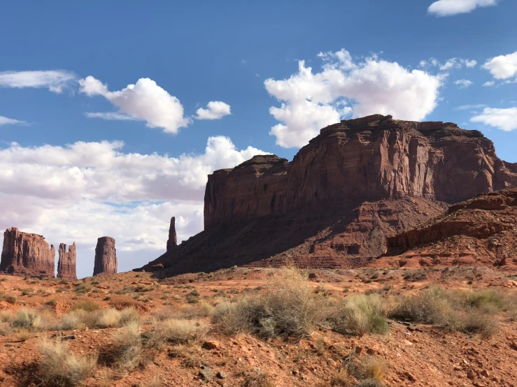 desert landscape with tall, rock formation in background