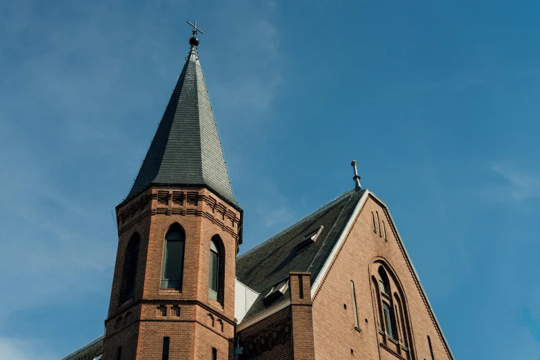 an old church with a steeple is under a blue sky