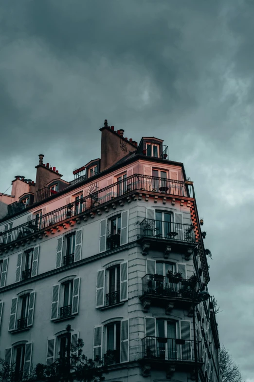 the front facade of an apartment building is red with black balconies