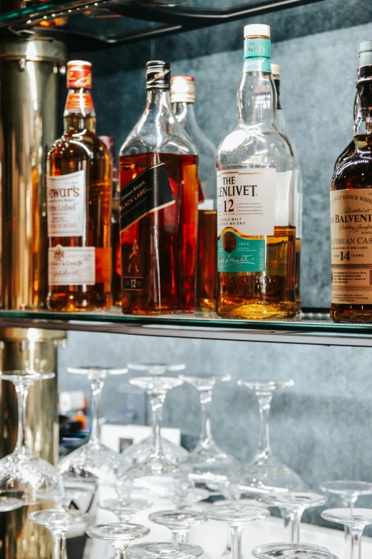 several glasses and bottles sitting on a shelf