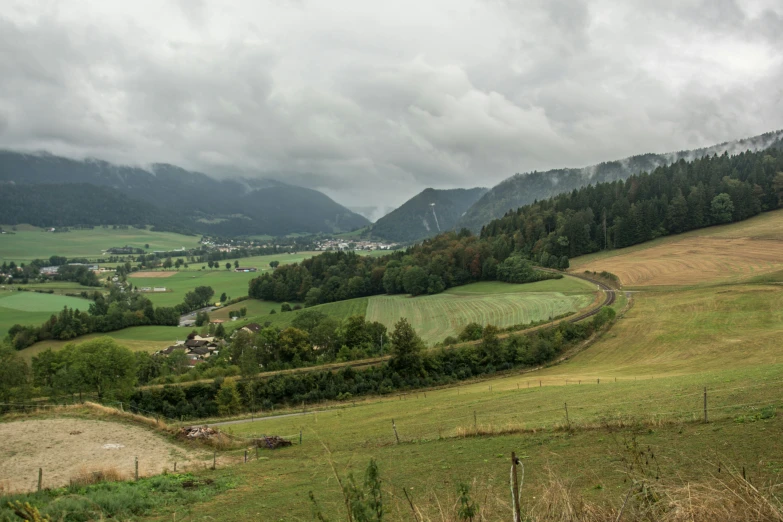 some people on the side of a hill with some mountains in the background