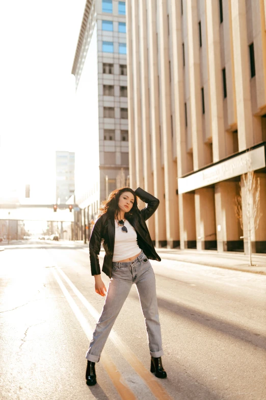 a woman standing in the middle of a road in front of a building