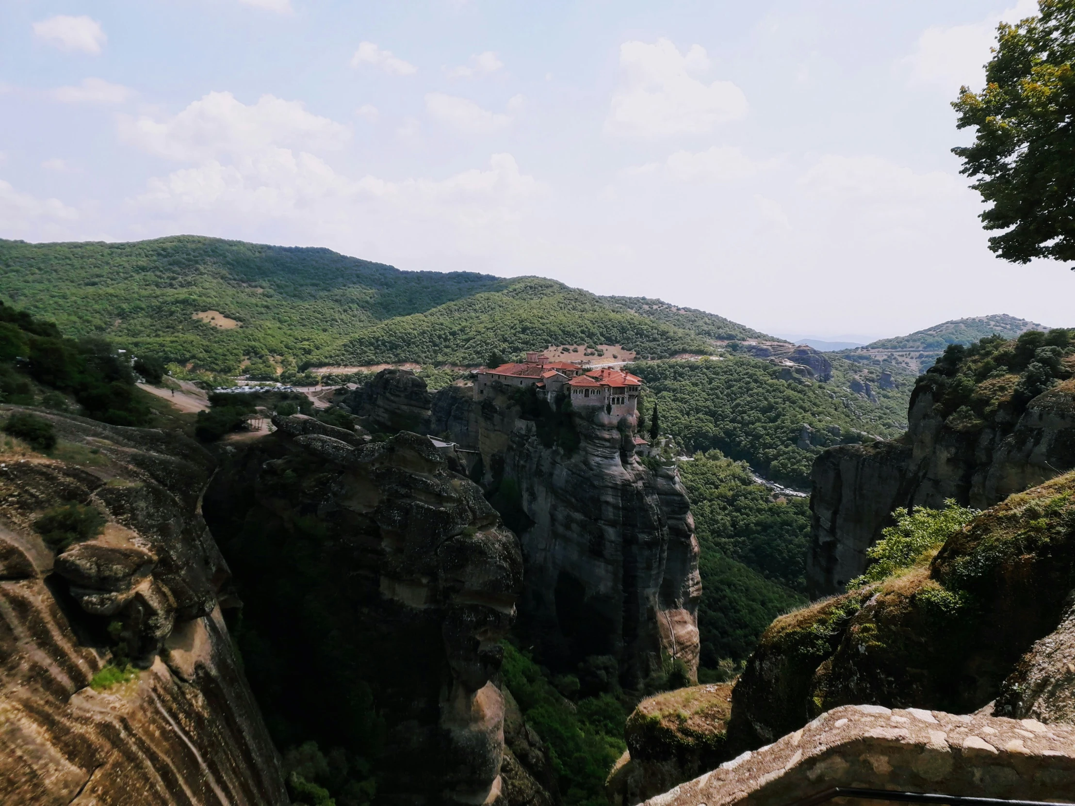 a large cliff with a small city in the background