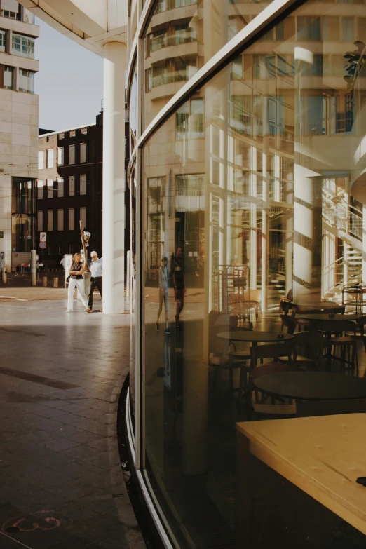 two people standing near a table in front of a window