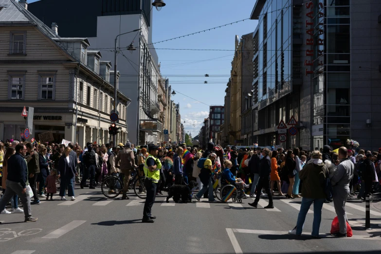 a street full of people standing and walking near buildings