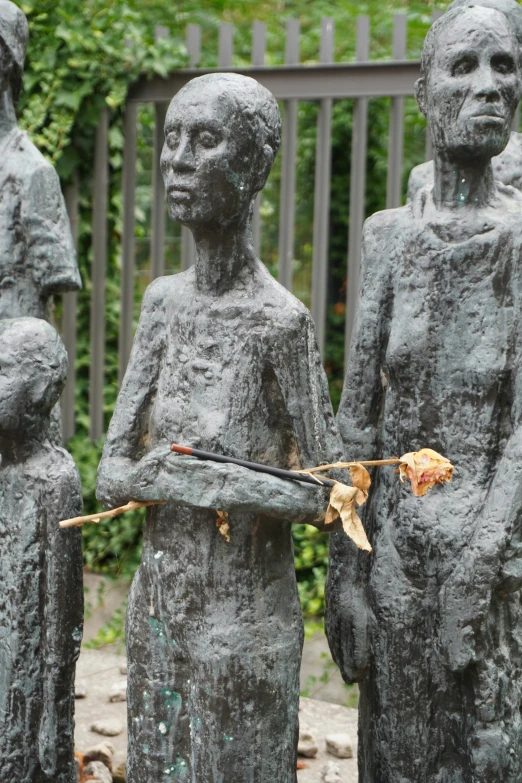 a statue holding up a flower that is on it