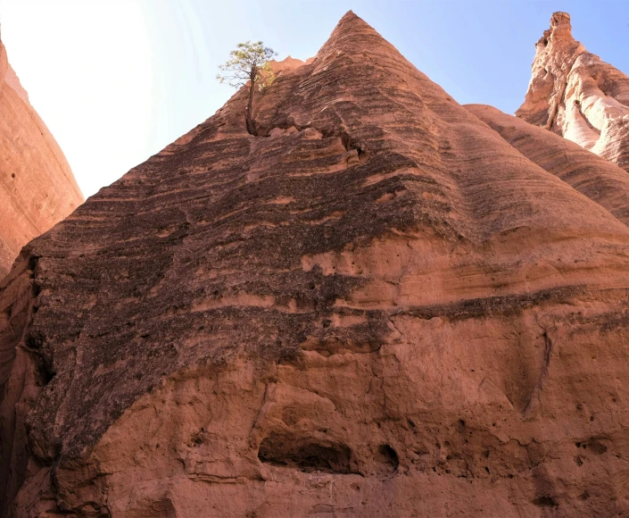 a person climbing on the side of a large rock