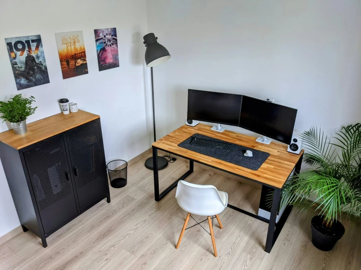 a clean room with a desk, speakers, plants and an office chair