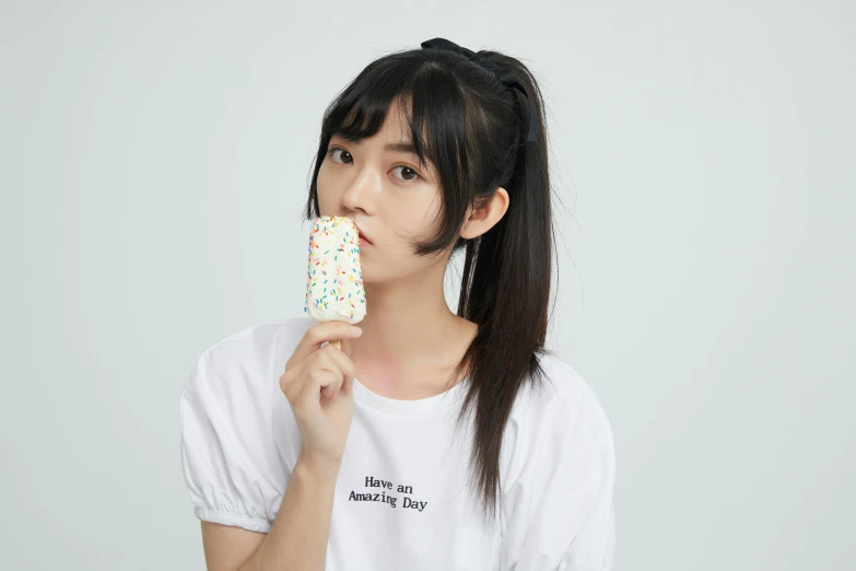 a young woman eating a cupcake covered in sprinkles