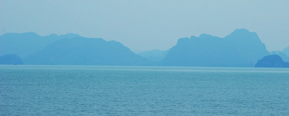 a body of water surrounded by mountains under a blue sky