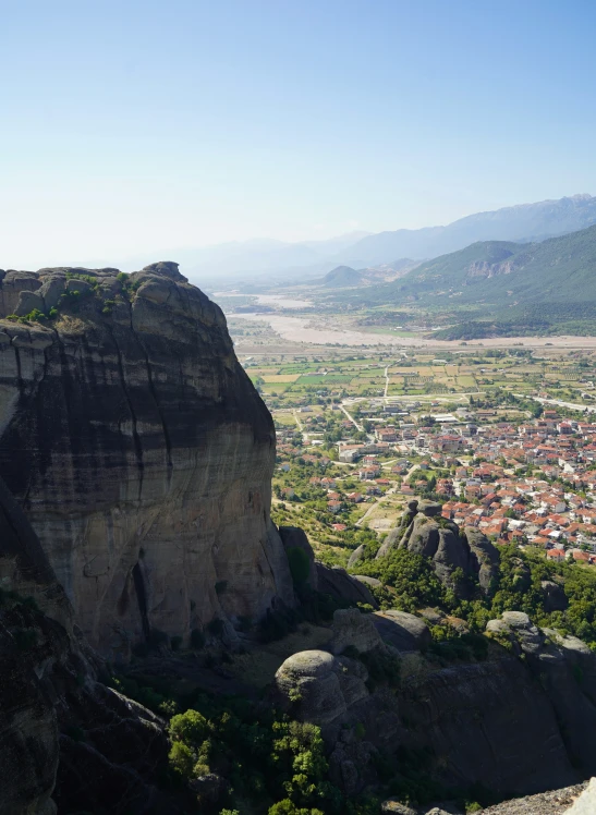 a scenic view of a large city next to some rocks