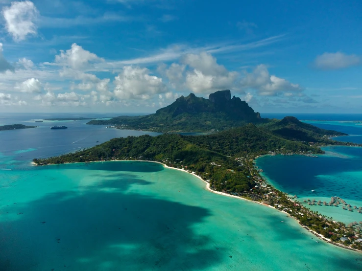 an island with lots of blue water next to a sandy shoreline