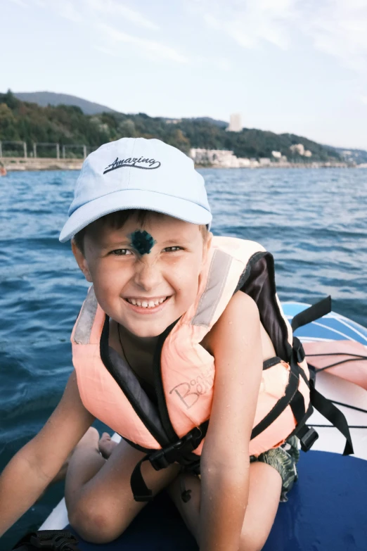 a  sitting on the back of a boat smiling