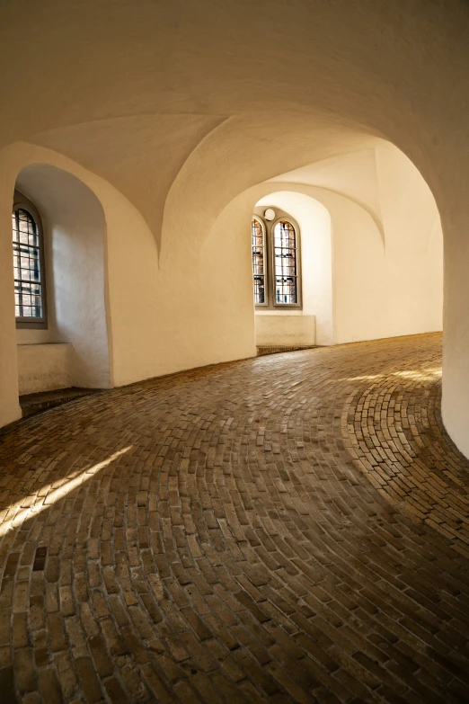 a stone floor has arched windows in it