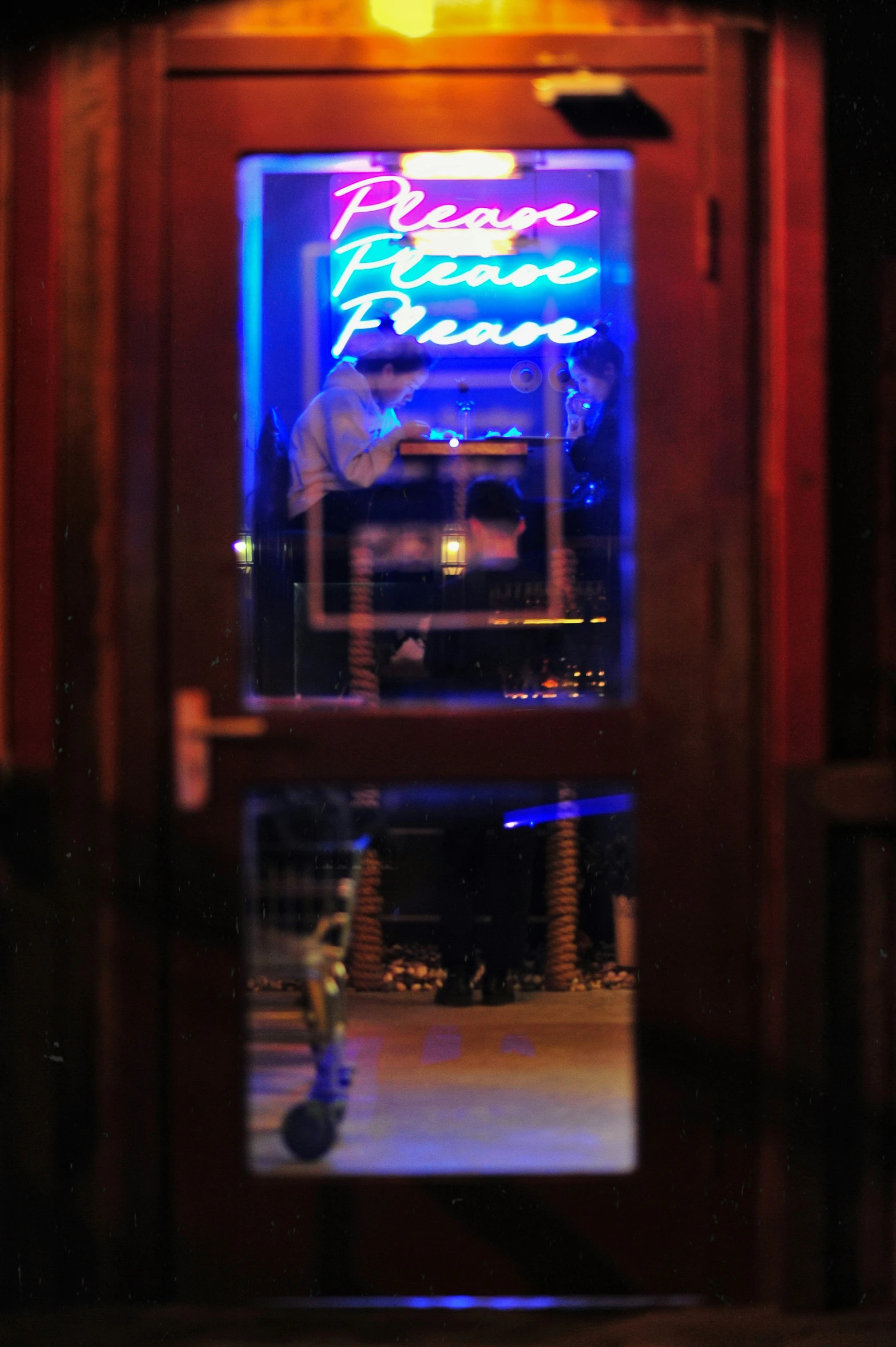 a colorful sign sitting behind the wooden door