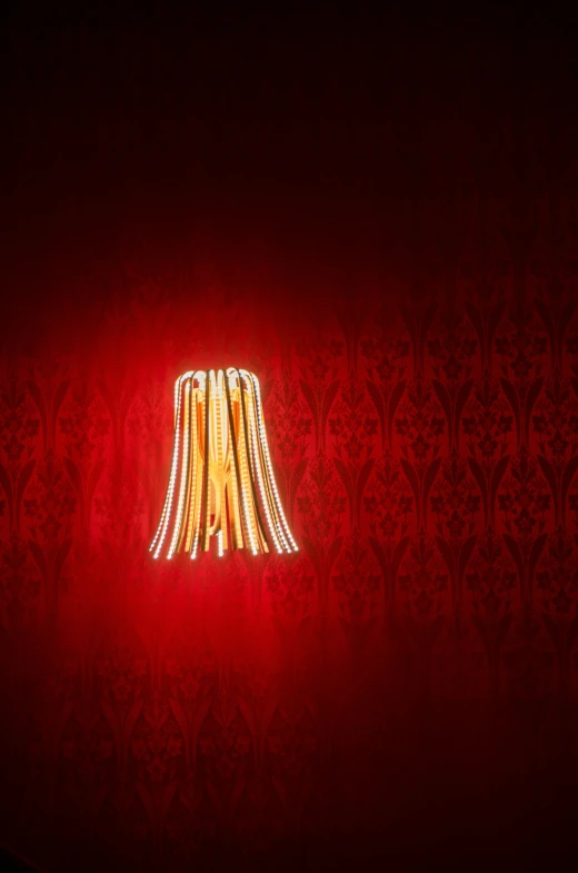 light bulb on a red wall with a black and white pattern