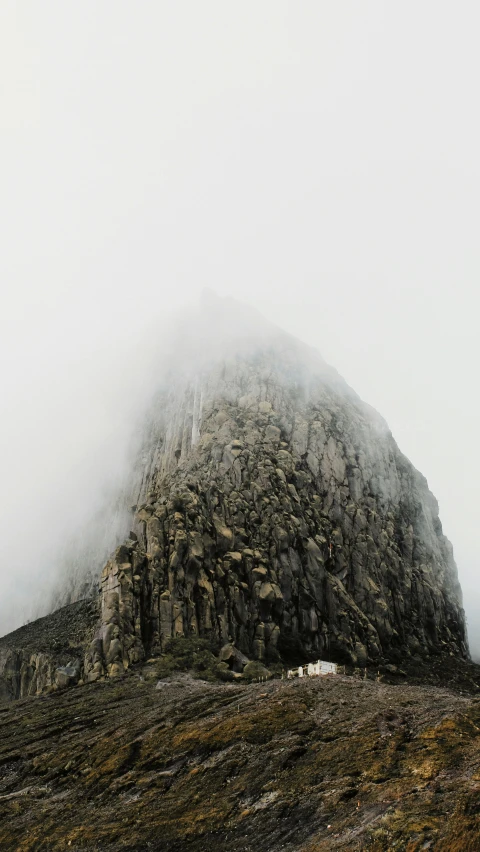 a mountain with rocks on the side in the middle of the day