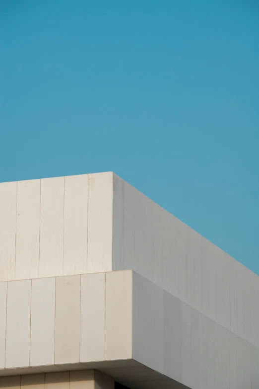 a bird flying over a building, and under the clear sky